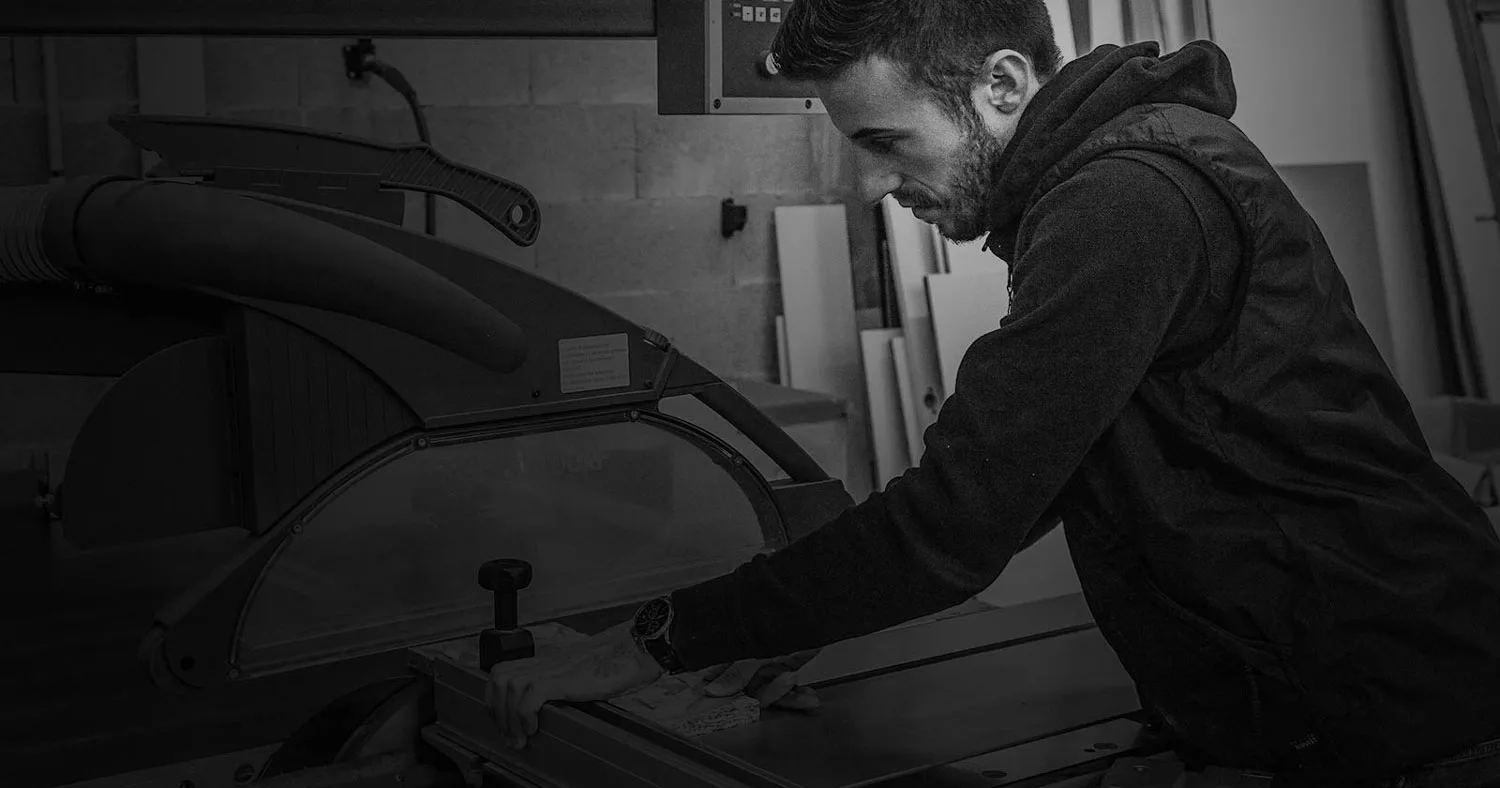 Un menuisier de l'atelier MZ Bois et Compagnie au travail, photo noir et blanc