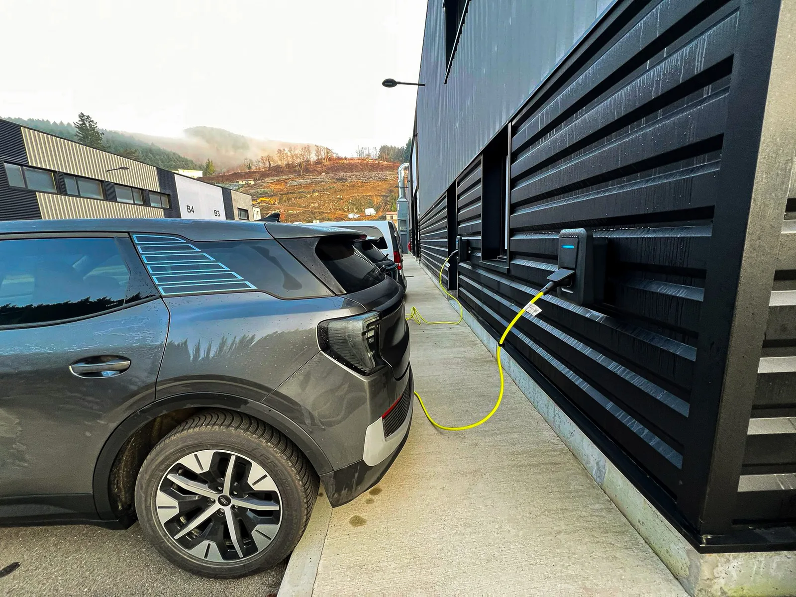 Véhicule électrique en charge devant l'atelier MZ Bois et Compagnie