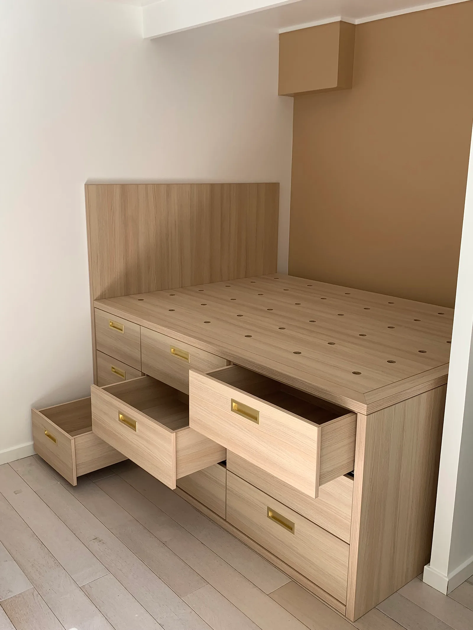 Détail des rangements intégrés sous le lit sur-mesure, réalisation MZ Bois et Compagnie